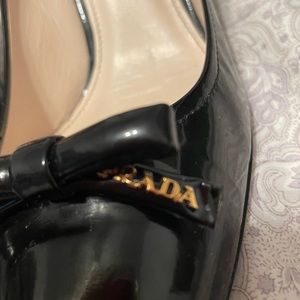 Patent leather Prada shows with bow and gold Prada insignia